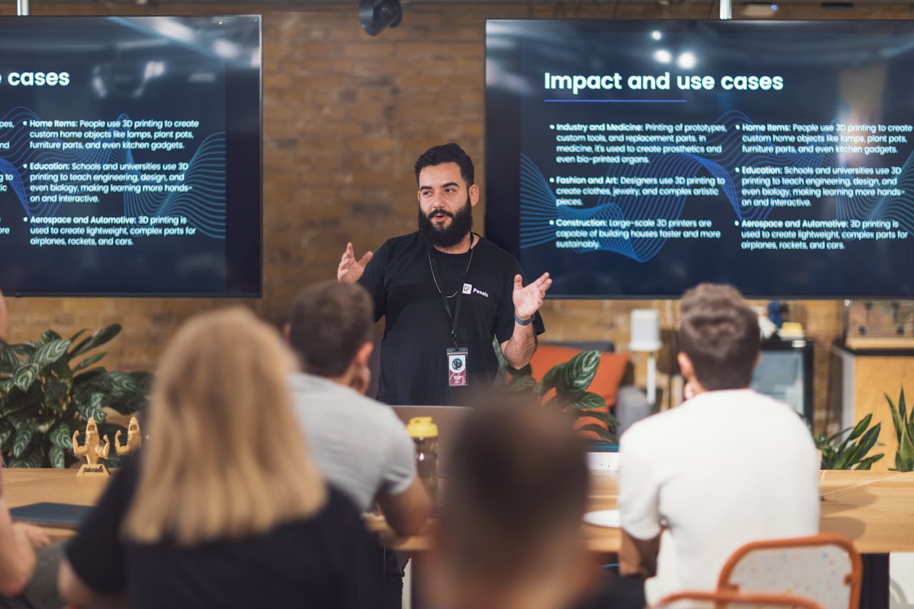 Services-03 Professional speaker discusses 3D printing applications with attentive audience in tech seminar.
